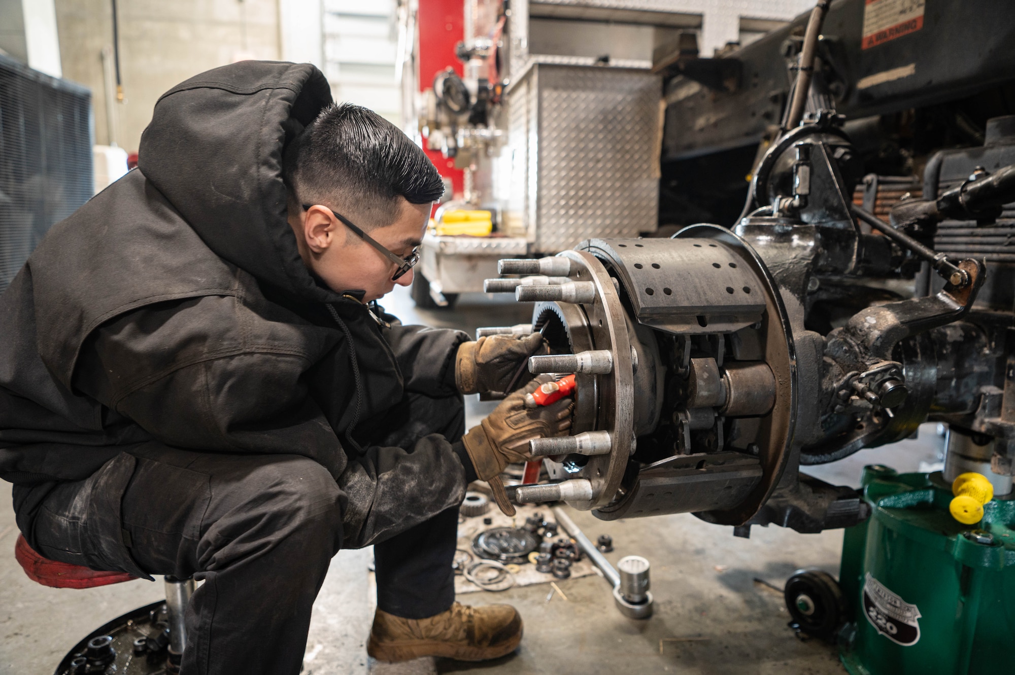 Staff Sgt. Zahit Aceves, 55th Logistics Readiness Squadron NCO-in-charge of firetruck maintenance, works on assembling wheel components during maintenance of a firetruck Feb. 21, 2025.