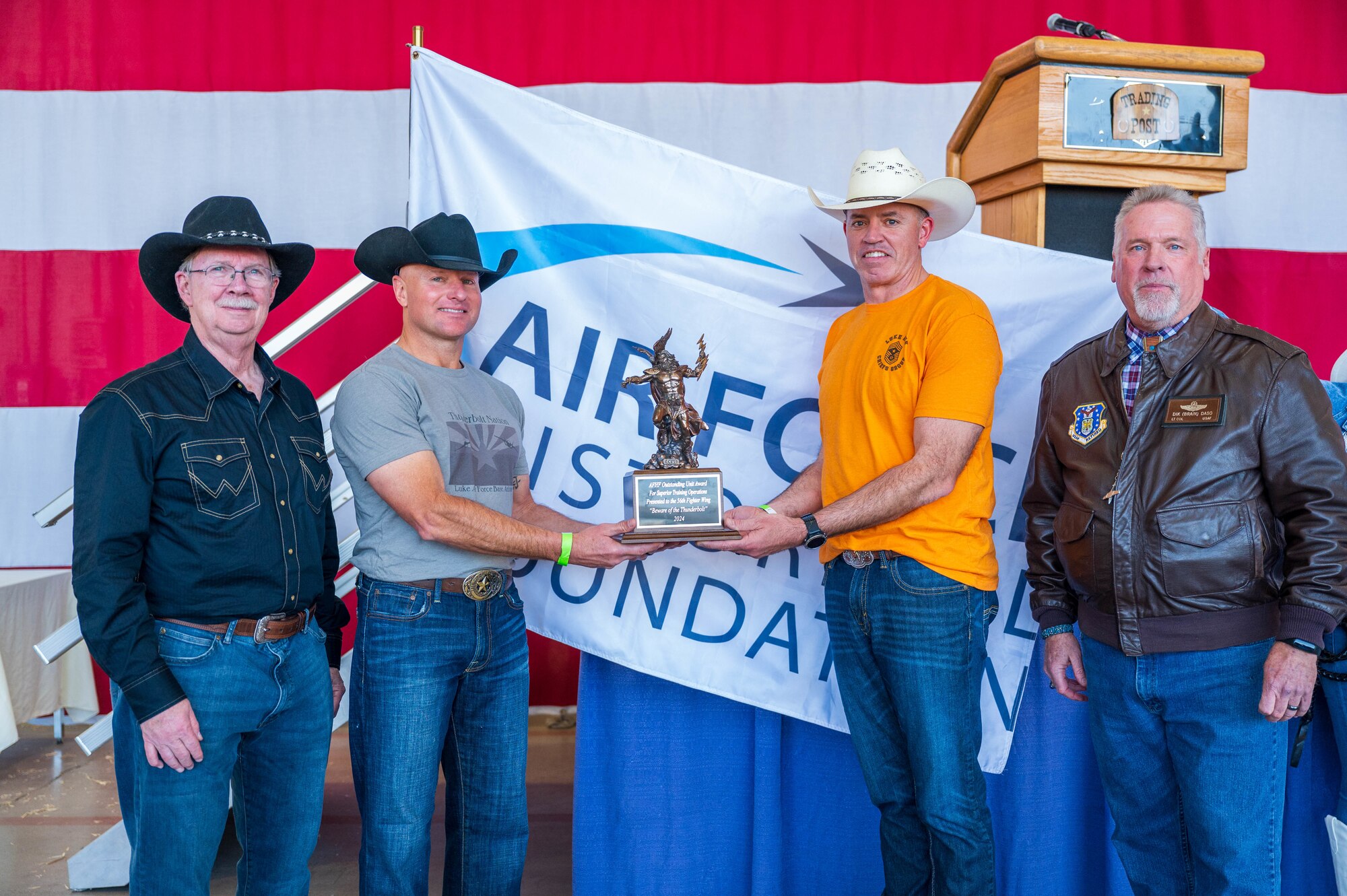 U.S. Air Force Brig. Gen. David Berkland (middle left,) 56th Fighter Wing commander, and U.S. Air Force Chief Master Sgt. Jason Shaffer (middle right,) 56th FW command chief, stand alongside retired U.S. Air Force Maj. Gen. John Berry (left,) Air Force Historical Foundation chair, and retired U.S. Air Force Lt. Col. Dik Daso (right,) AFHF executive director, after being awarded the Hap Arnold Thunderbolt award during the 2025 annual awards ceremony, Feb. 21, 2025, at Luke Air Force Base, Arizona.