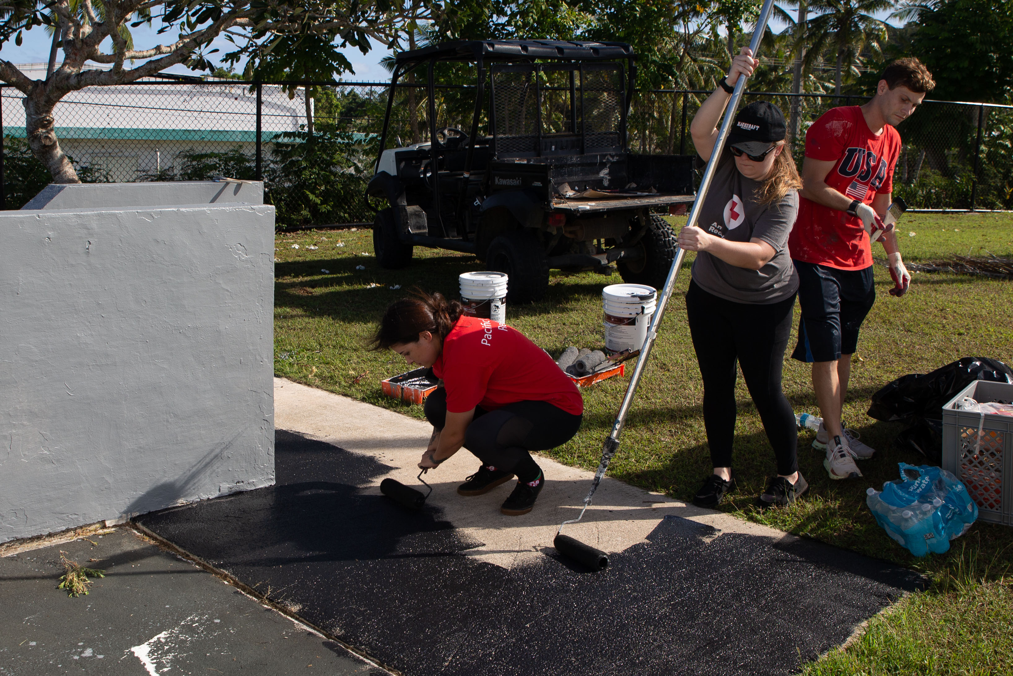 U.S. Navy Sailors paint the sidewalk during a volunteer event at the Guam Veterans Cemetery, Piti, Guam, Feb. 8, 2025. Marines and Sailors volunteered with the Red Cross to help revitalize the cemetery grounds and honor the veterans and their families that were laid to rest there. (U.S. Marine Corps photo by Lance Cpl. Afton Smiley)
