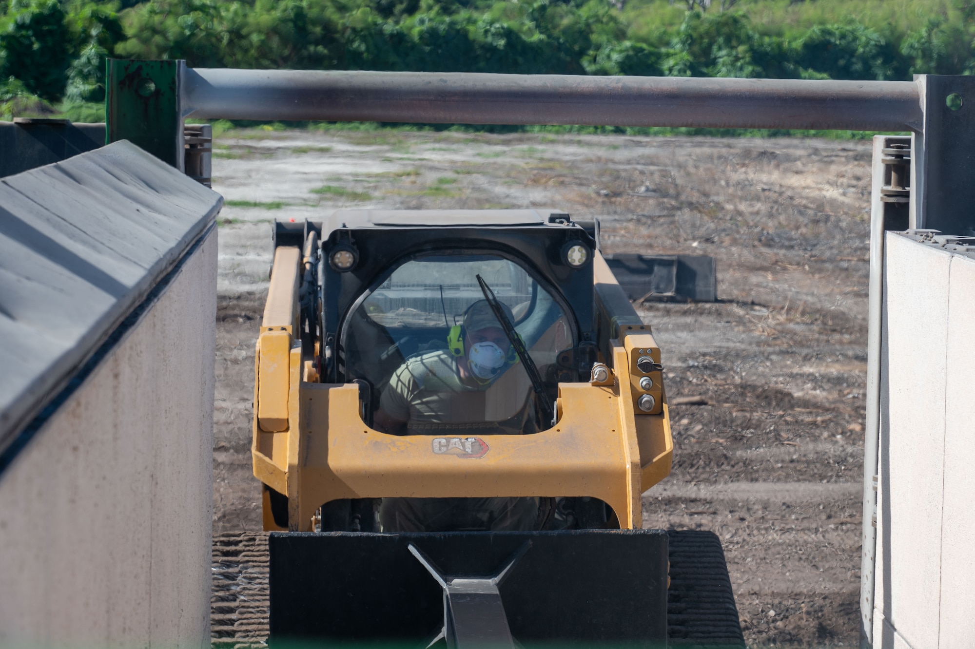 U.S. Air Force Tech. Sgt. Cody Rohrs, 513th Expeditionary Rapid Engineer Deployable Heavy Operations Repair Squadron Engineers Squadron pavement and construction equipment craftsman, uses a Compact Track Loader (CTL) at Tinian North Airfield, Tinian, Feb. 03, 2025. This is the first time REDHORSE is utilizing  Air Curtain Incinerators in efforts to burn and dispose of all the cleared green waste in an environmentally friendly way, the CTL is used to move the waste. (U.S. Air Force photo by Airman 1st Class Manasseh Demissie)