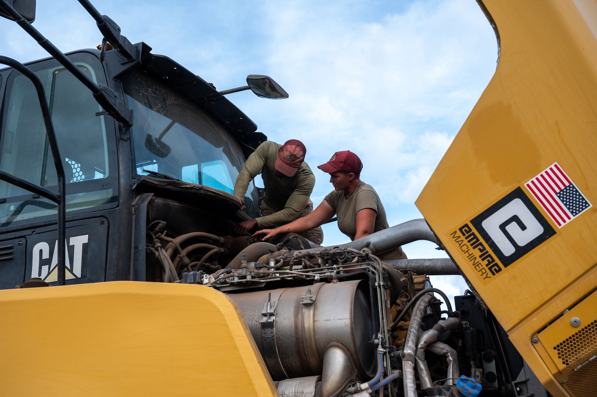 U.S. Air Force Senior Airman Savian Jones, 513th Expeditionary Rapid Engineer Deployable Heavy Operations Repair Squadron Engineers Squadron journeyman vehicle technician, left, and Tech. Sgt. Kelly Salvin, 513th Expeditionary REDHORSE Squadron logistic lead, diagnose a leak in the hydraulic motor on a rock truck at Tinian’s North Field, Tinian, Feb. 06, 2025. The rock truck is essential for transporting cleared jungle material from worksites to the Air Curtain Incinerator (ACI) burn piles. (U.S. Air Force photo by Airmen 1st Class Manasseh Demissie)
