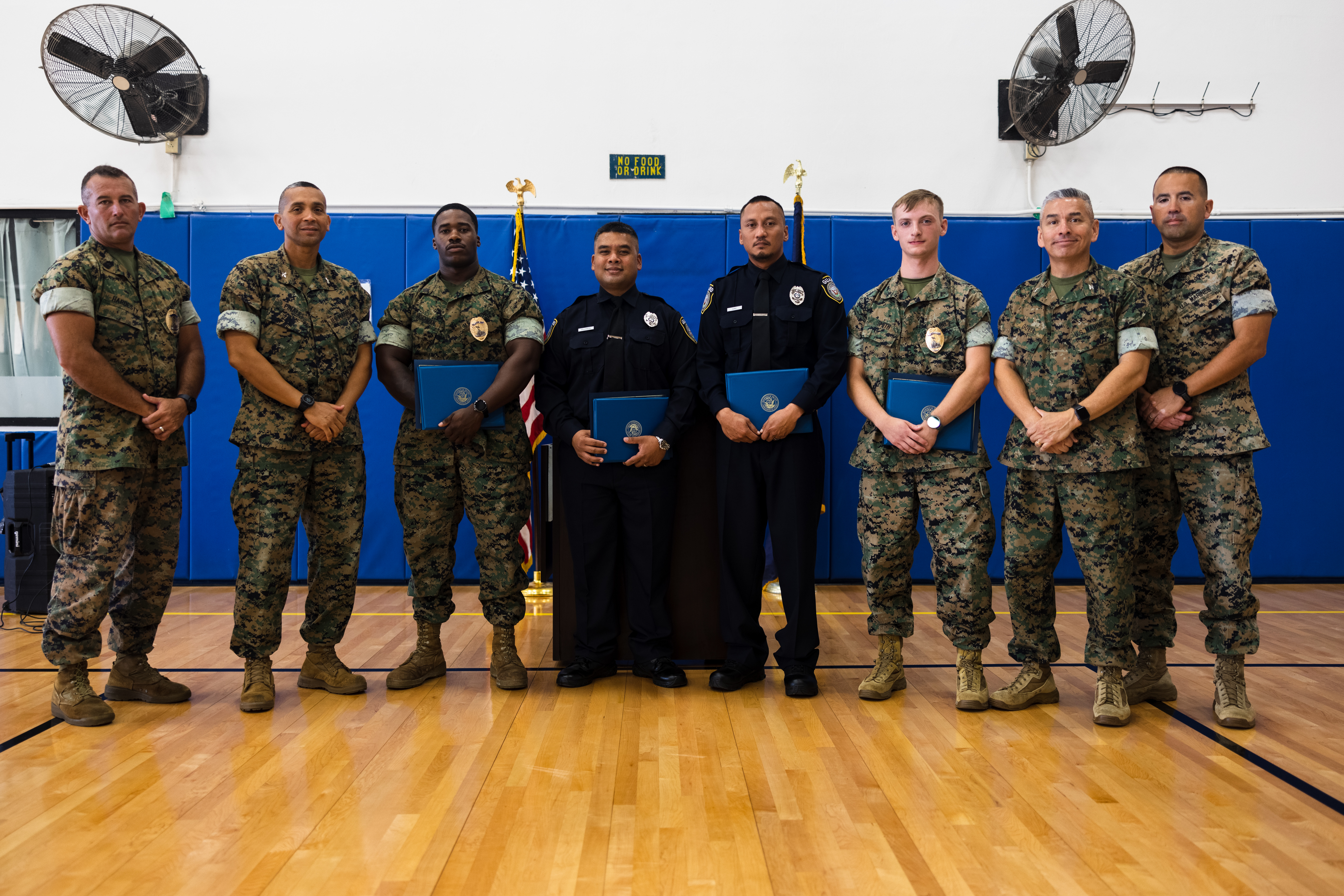 U.S. Marine Corps senior leaders pose for a group photo with the new graduates of the Naval Security Guard Training course after a graduation ceremony on Marine Corps Base Camp Blaz, Guam, Feb. 21, 2025. The course introduced the military police to military law enforcement, evidence handling, risk management, unarmed self-defense, and mechanical advantage control holds. (U.S. Marine Corps photo by Cpl. Brayden Daniel)