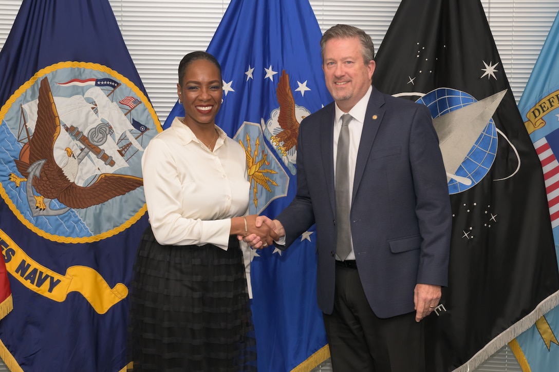 Two people pose for a picture after a coin presentation.