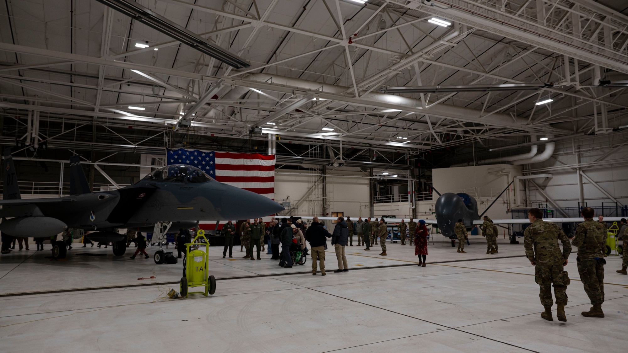 Airmen and civilians gather around an F-15 EX Eagle II assigned to Eglin Air Force Base, Fla., and an RQ-4 Global Hawk Block 40 during a tour commemorating Project Streak Eagle and world record setting airframes at Grand Forks Air Force Base, N.D., Feb. 20, 2025.