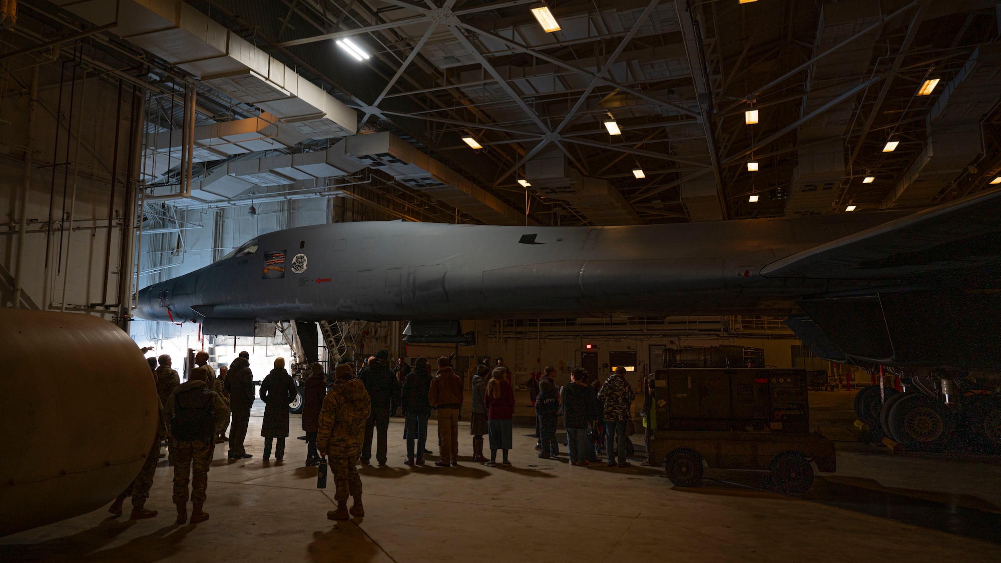 Airmen and civilians gather around a B-1B Lancer assigned to Ellsworth Air Force Base, S.D., during a tour commemorating Project Streak Eagle and world record setting airframes at Grand Forks AFB, N.D., Feb. 20, 2025.