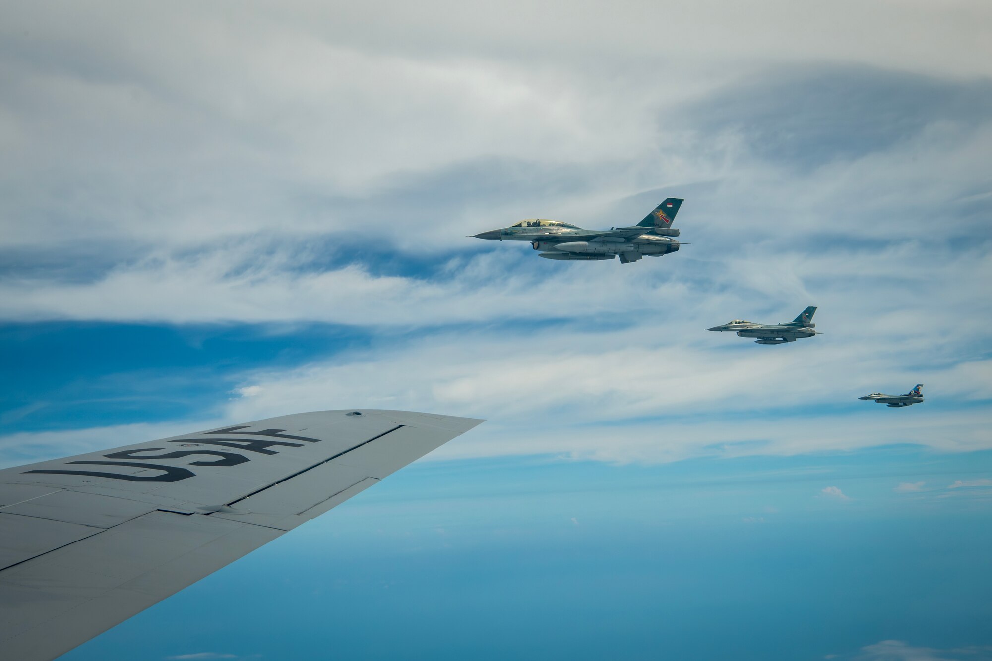 Three Indonesian Air Force (IDAF) F-16 Fighting Falcon's fly alongside a Hawaii Air National Guard KC-135 Stratotanker assigned to the 203rd Air Refueling Squadron during an air-to-air refueling training mission over Indonesia, Feb. 17, 2025.