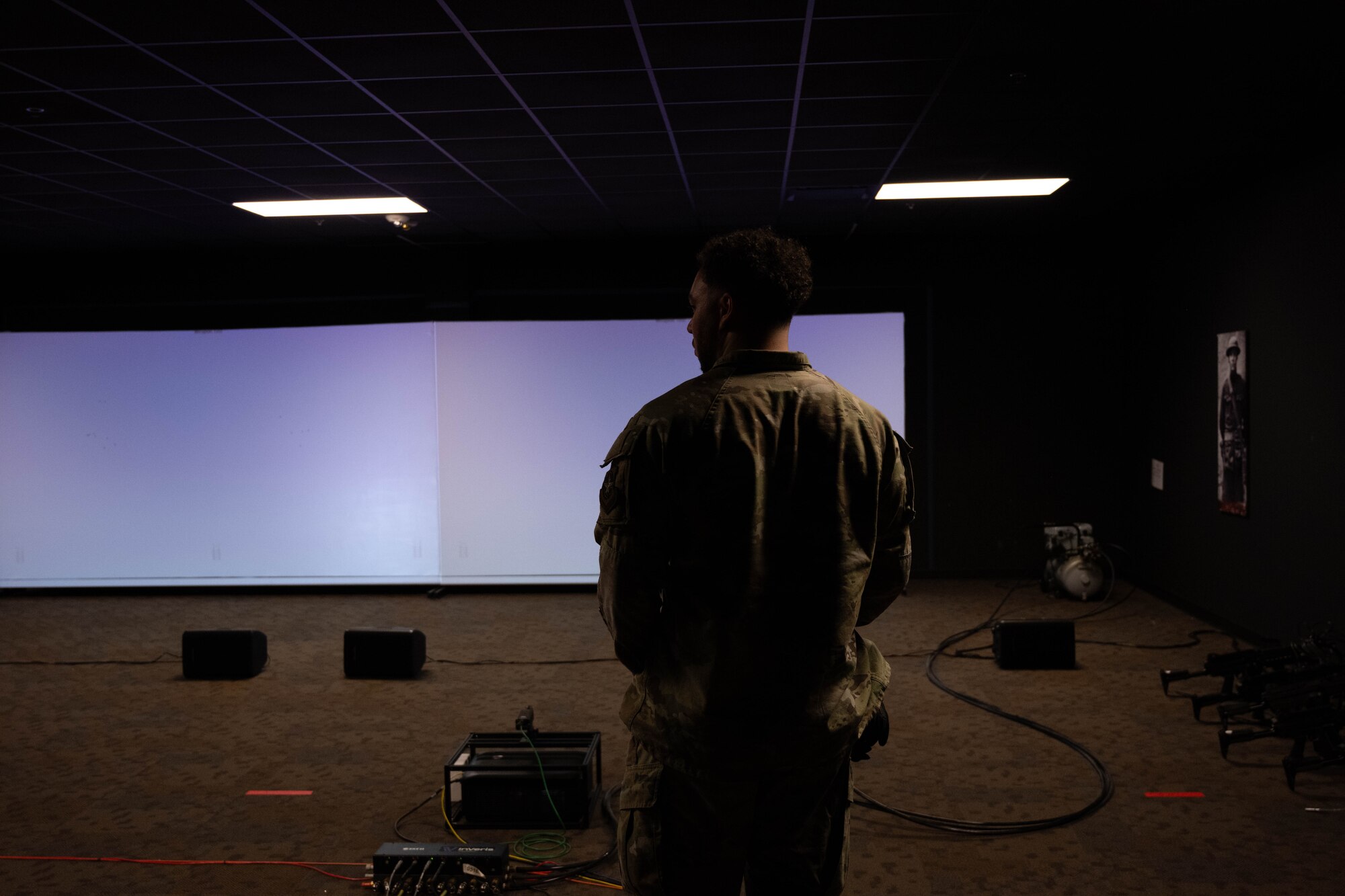 A U.S Airman stands waiting for weapons training simulator to start.