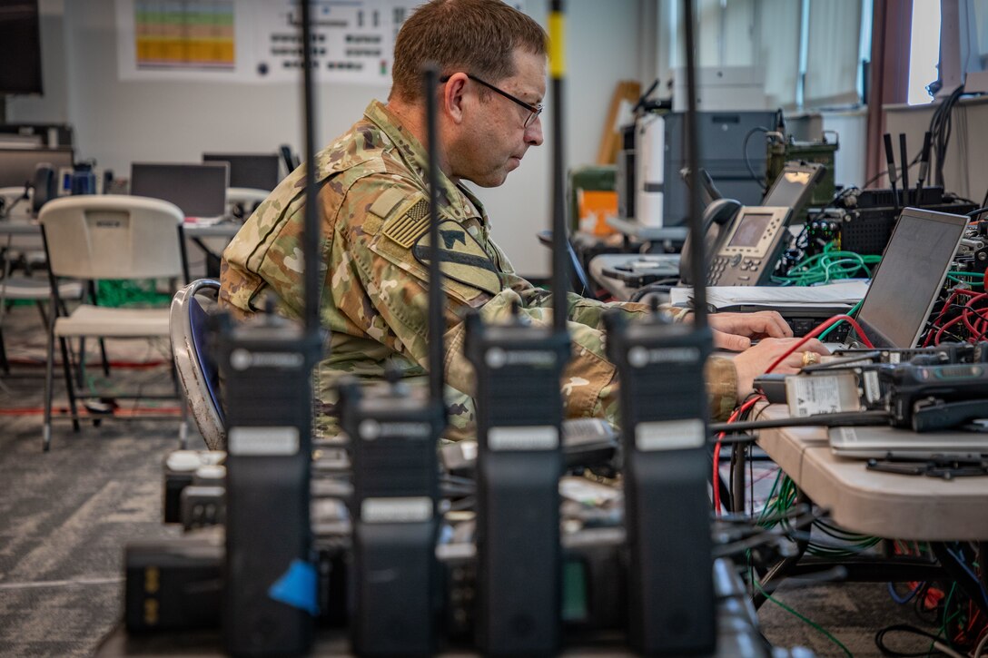 An electromagnetic spectrum manager assigned to Joint Task Force Southern Guard programs radios at Naval Station Guantanamo Bay, Cuba, Feb. 18, 2025. Joint Task Force Southern Guard is supporting illegal aliens holding operations led by the Department of Homeland Security at Naval Station Guantanamo Bay, Cuba. (U.S. Army photo by Staff Sgt. ShaTyra Cox) (Staff Sgt. ShaTyra Reed-Cox)