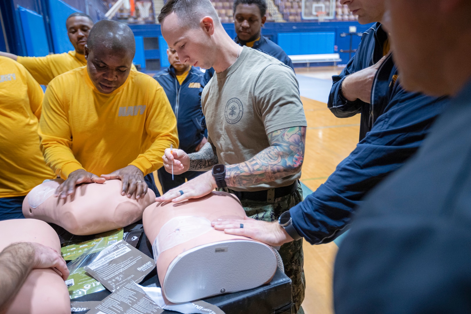 SurgeMain Sailors practice the procedure for inserting a large-bore needle in order to decompress a simulated tension pneumothorax Feb. 2, during Tactical Combat Casualty Care training on Naval Base Kitsap-Bremerton, Washington. The program helped kick off the SurgeMain Sailors' annual two-week training deployment at Puget Sound Naval Shipyard & Intermediate Maintenance Facility. Established in 2005, SurgeMain has more than 2,000 Reserve Sailors across 75 units. (U.S. Navy photo by MC1 Jeffrey J. Hanshaw)