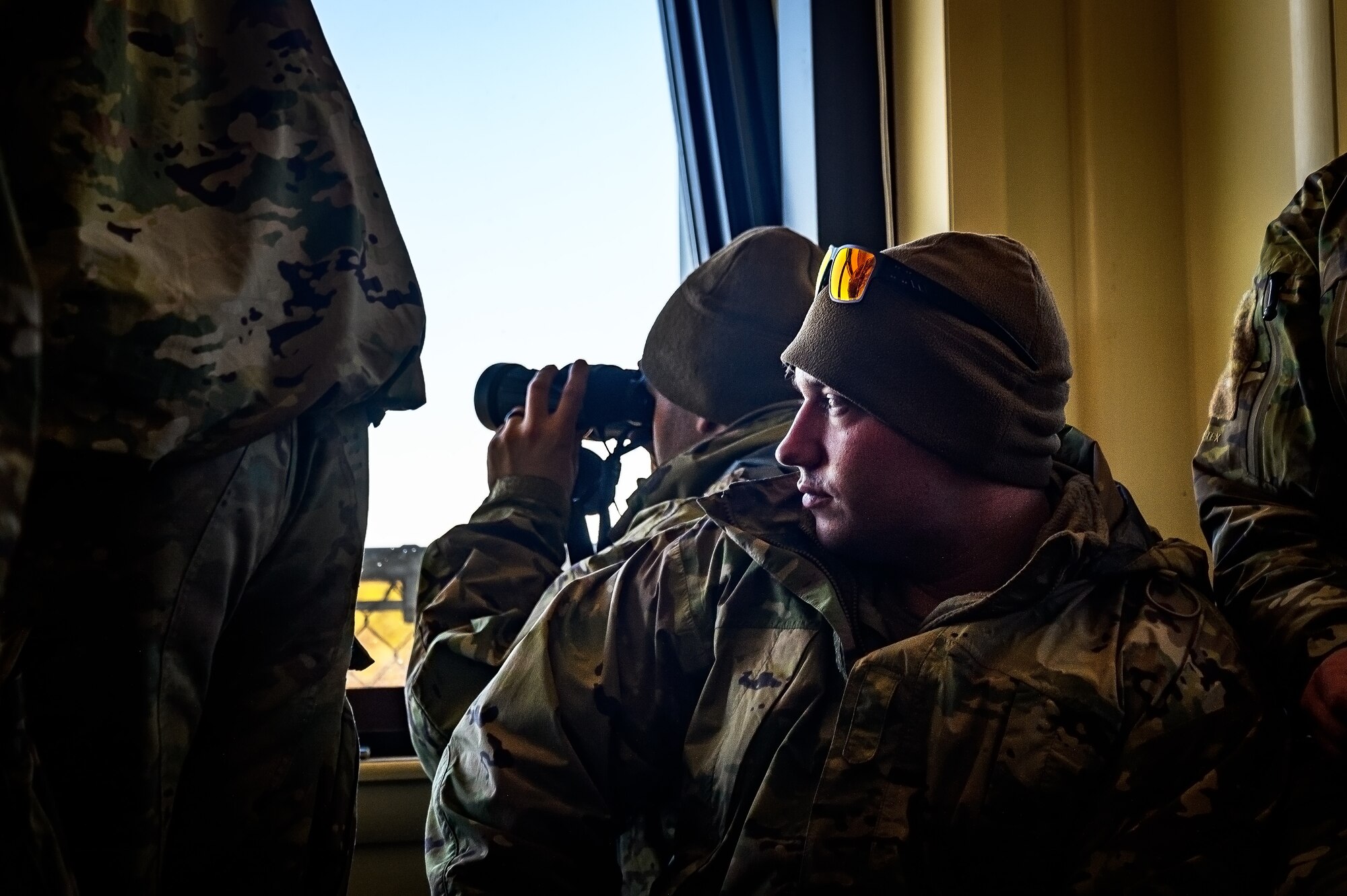 U.S. Army Soldiers assigned to the 1-102nd Infantry Regiment, use binoculars for target identification during a platoon live-fire exercise at Joint Base McGuire-Dix-Lakehurst, N.J., Feb. 1, 2025. The platoon live-fire exercise incorporated land navigation through indirect fire and utilized unmanned aerial vehicle systems for both reconnaissance and offensive maneuvers. (U.S. Air Force photo by Senior Airman Matt Porter)