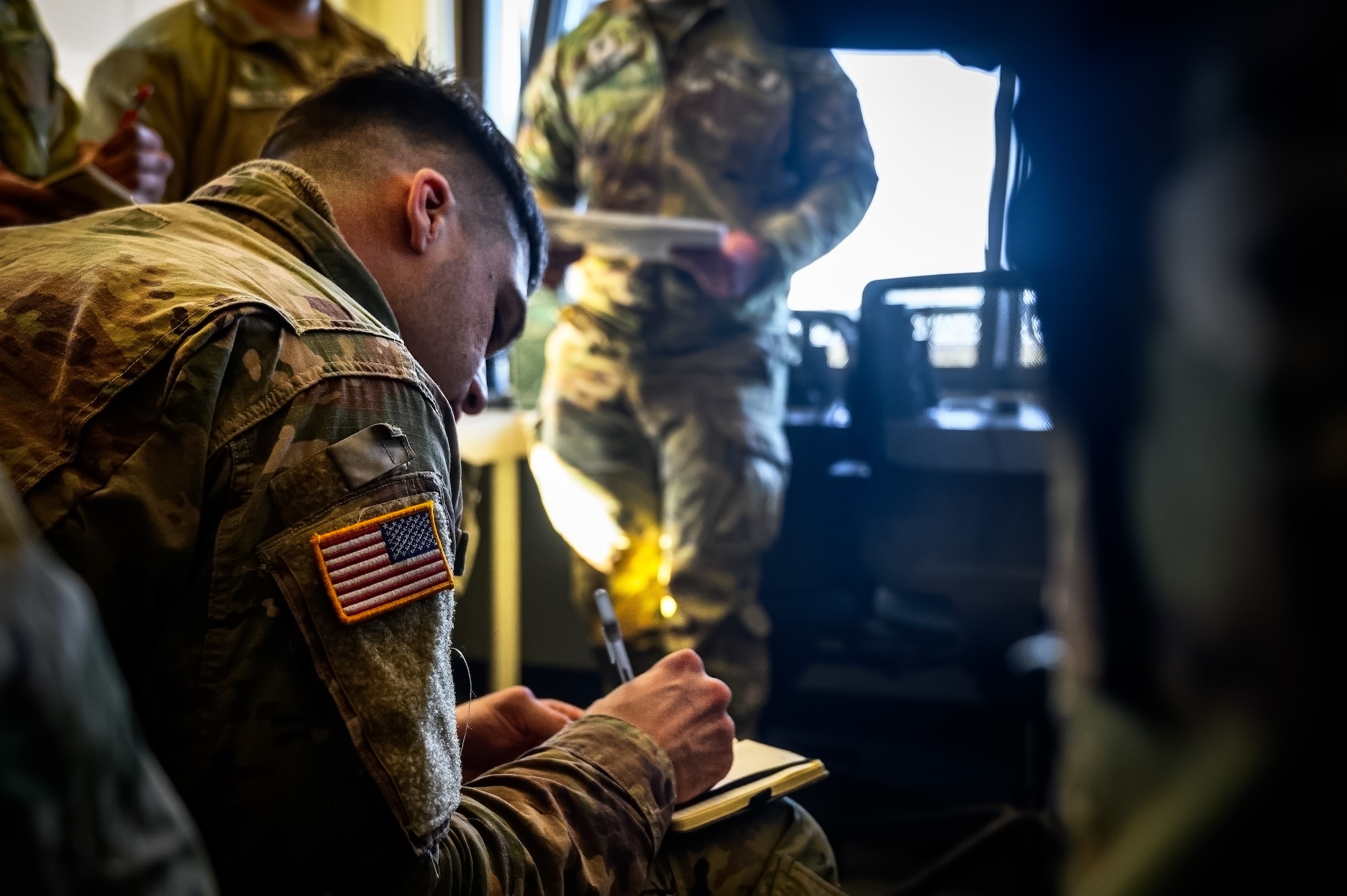 U.S. Army Sgt. Devon Calhoun, 1-102nd Infantry Regiment infantryman, writes down coordinates in preparation for a platoon live-fire exercise at Joint Base McGuire-Dix-Lakehurst, N.J., Feb.1, 2025. The platoon live-fire exercise incorporated land navigation through indirect fire and utilized unmanned aerial vehicle systems for both reconnaissance and offensive maneuvers. (U.S. Air Force photo by Senior Airman Matt Porter)