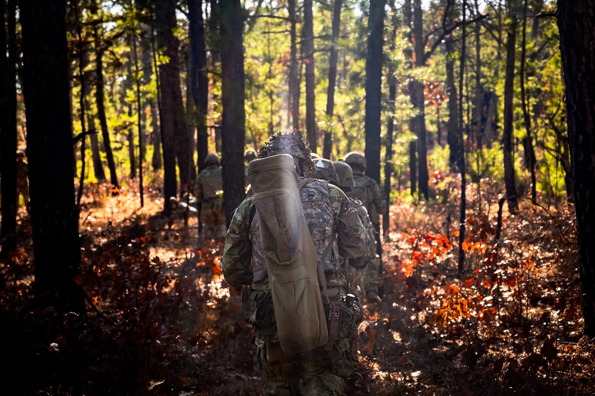 U.S. Army Soldiers assigned to the 1-102nd Infantry Regiment, traverse through a game trail during a platoon live-fire exercise at Joint Base McGuire-Dix-Lakehurst, N.J., Feb. 1, 2025. The platoon live-fire exercise incorporated land navigation through indirect fire and utilized unmanned aerial vehicle systems for both reconnaissance and offensive maneuvers. (U.S. Air Force photo by Senior Airman Matt Porter)
