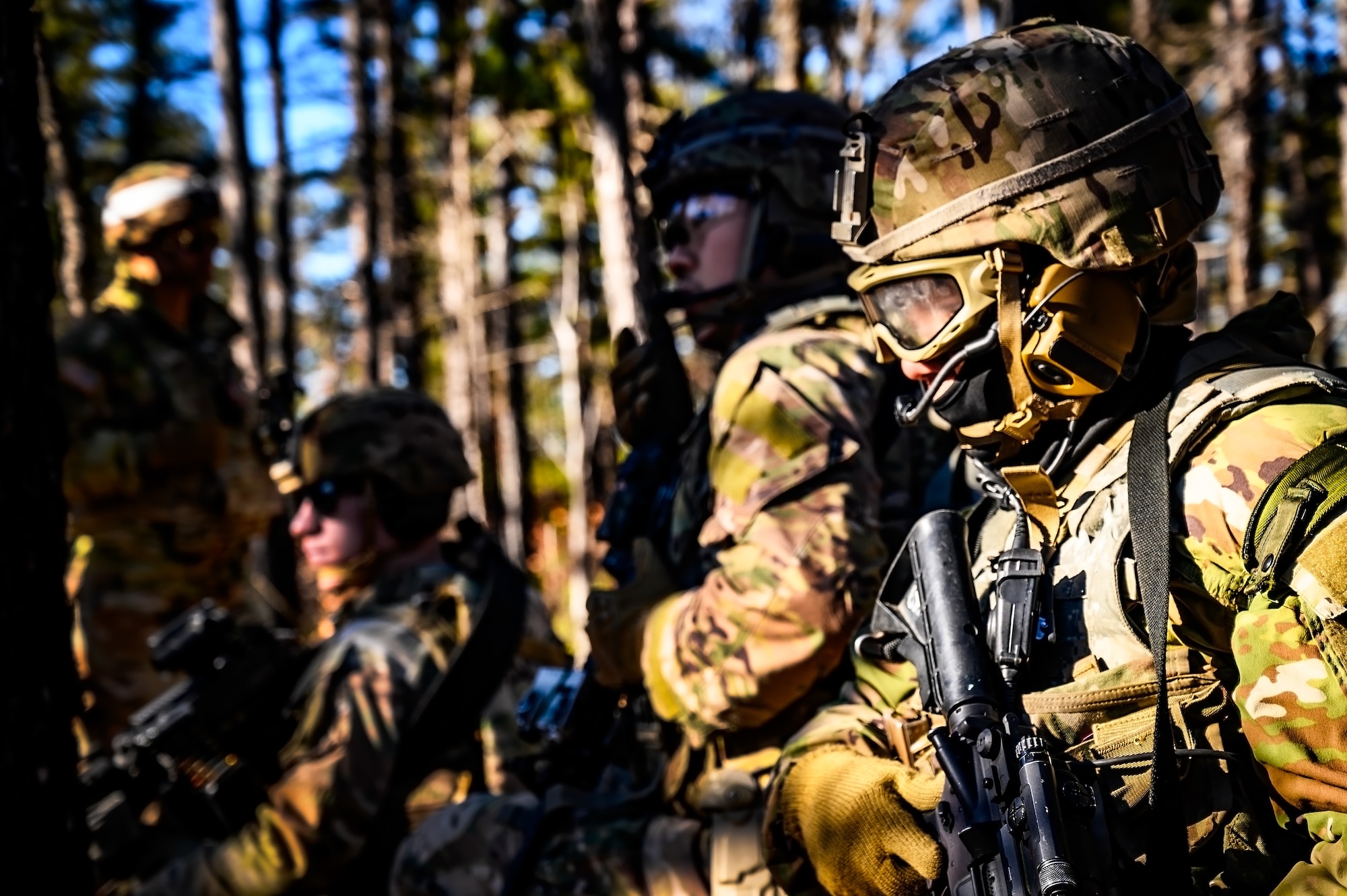 U.S. Army Soldiers assigned to the 1-102nd Infantry Regiment, await instruction during a platoon live-fire exercise at Joint Base McGuire-Dix-Lakehurst, N.J., Feb. 1, 2025. The platoon live-fire exercise incorporated land navigation through indirect fire and utilized unmanned aerial vehicle systems for both reconnaissance and offensive maneuvers. (U.S. Air Force photo by Senior Airman Matt Porter)