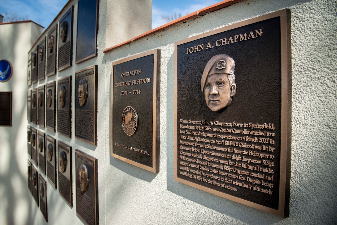 Several bronze plaques line a wall.