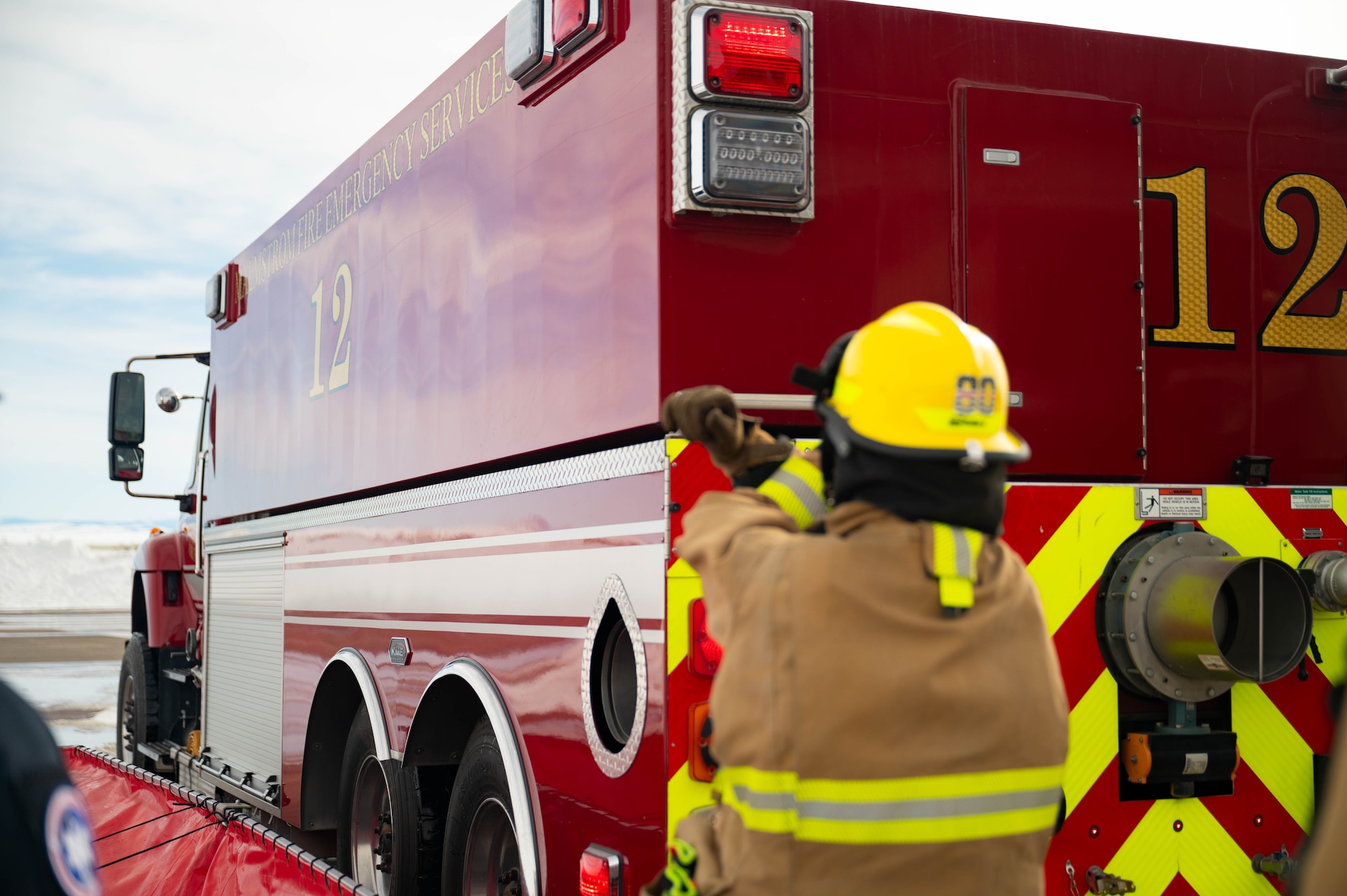 A man in uniform works on a fire truck.