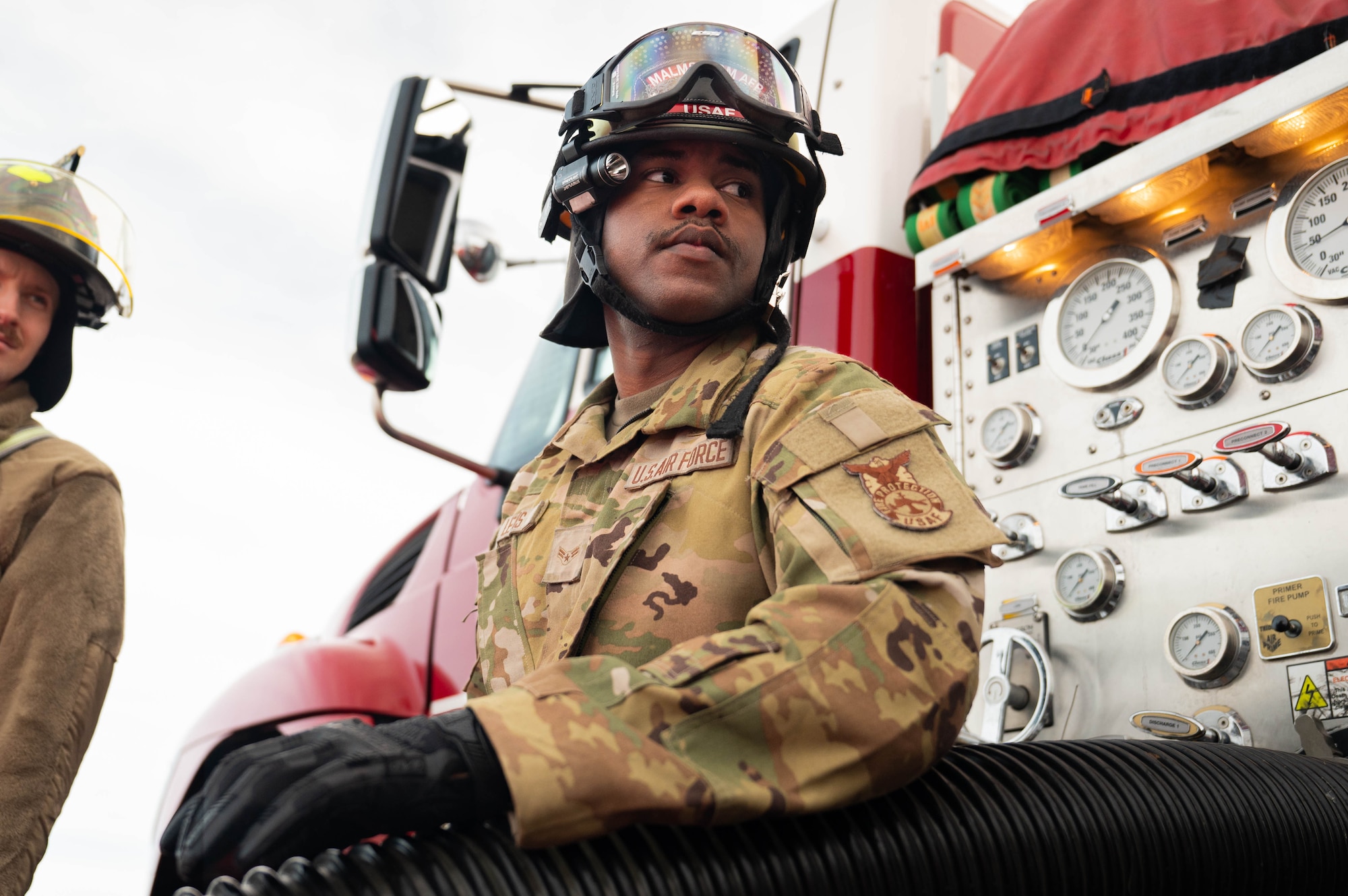 A man in uniform works on a fire truck.