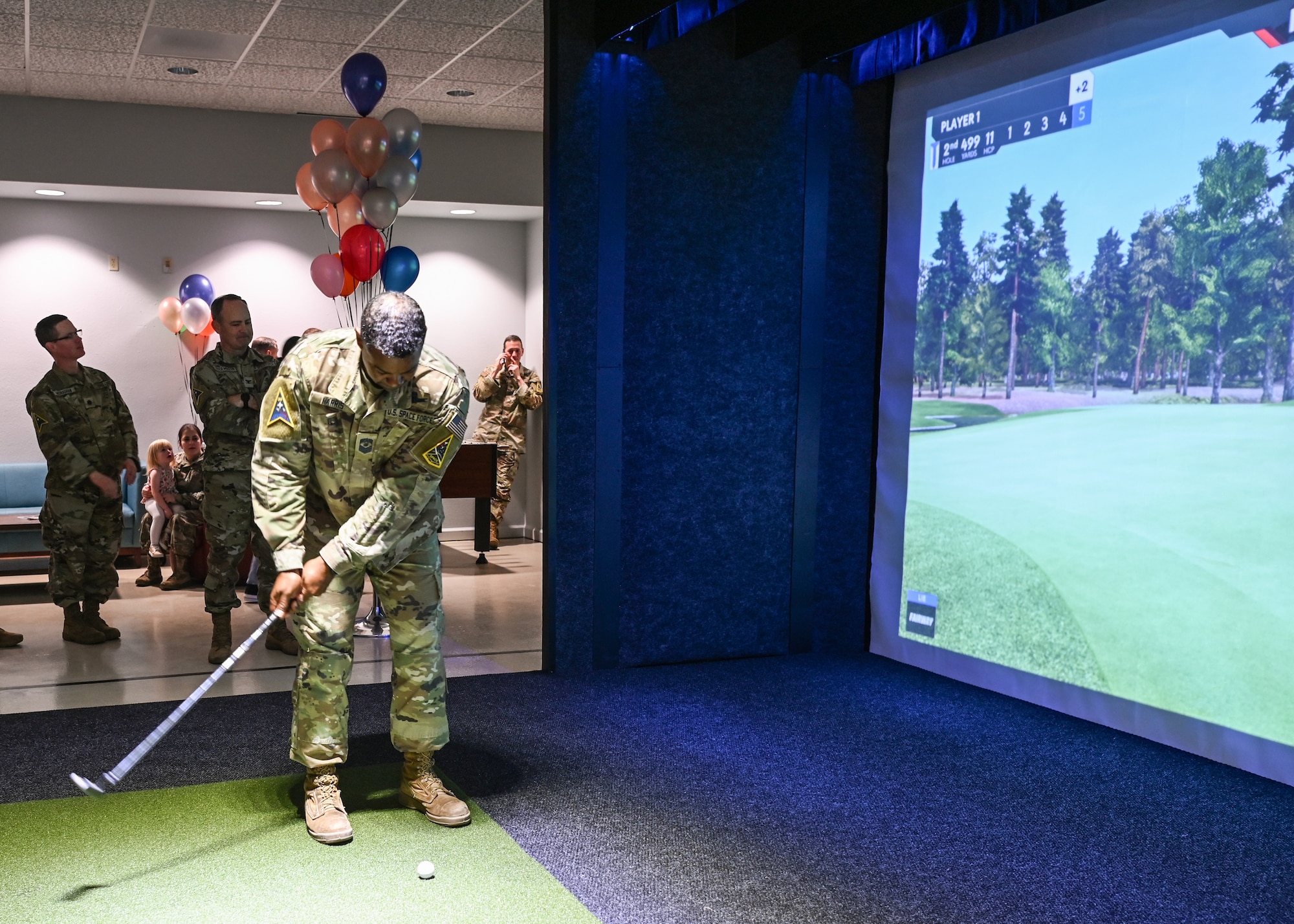 A Space Launch Delta 30 senior enlisted leader, tests out a virtual golfing simulator during the Pacific Coast Center gaming room grand opening at Vandenberg Space Force Base.