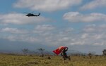 U.S. Marine Corps Cpl. Manuel Sandoval, a native of Mexico and an infantry rifleman with 3d Littoral Combat Team, 3d Marine Littoral Regiment, 3d Marine Division, uses a service flag to signal a landing zone for a U.S. Army UH-60 Blackhawk during a training exercise at Pohakuloa Training Area, Hawaii, Feb. 12, 2025.