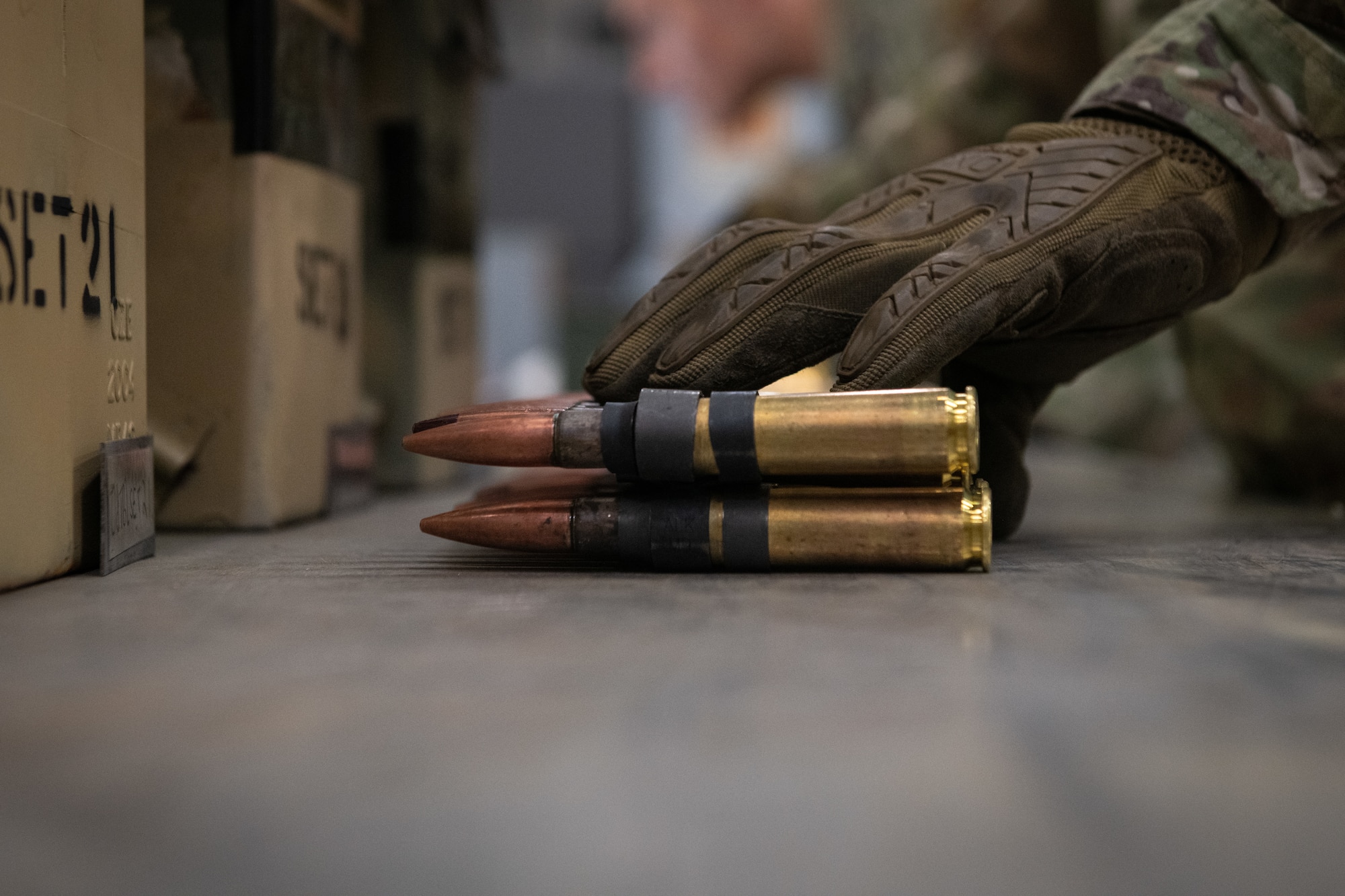 An Airman grabs ammo rounds with their hand.