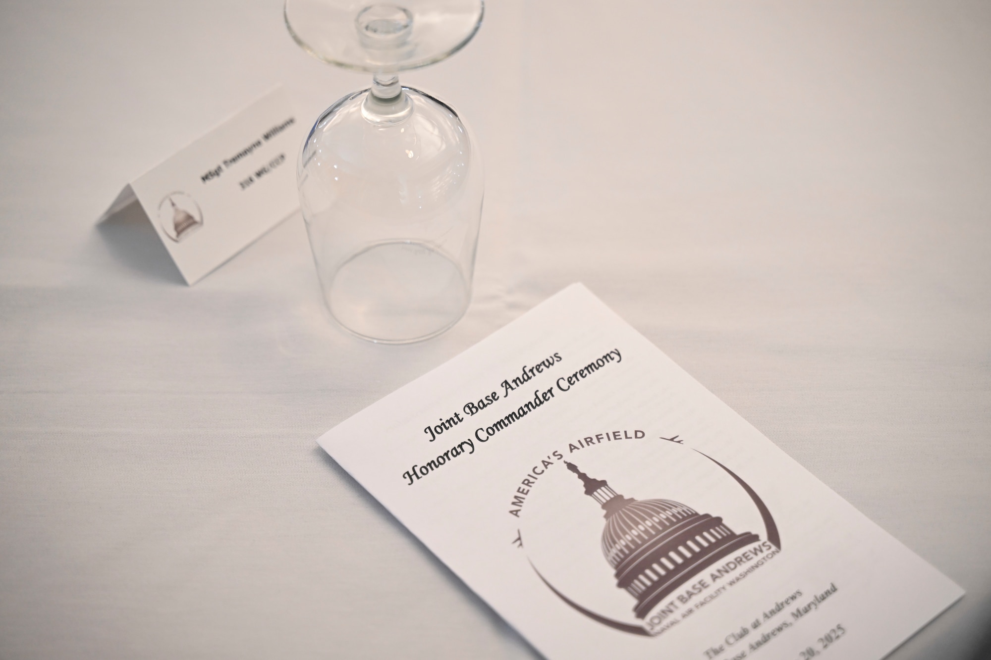 A program for the Honorary Commander Ceremony rests on a table at Joint Base Andrews, Md., Feb. 20, 2025. The event served as an opportunity for military leaders to connect with local civic leaders and strengthen community ties. (U.S. Air Force photo by Senior Airman Gianluca Ciccopiedi)