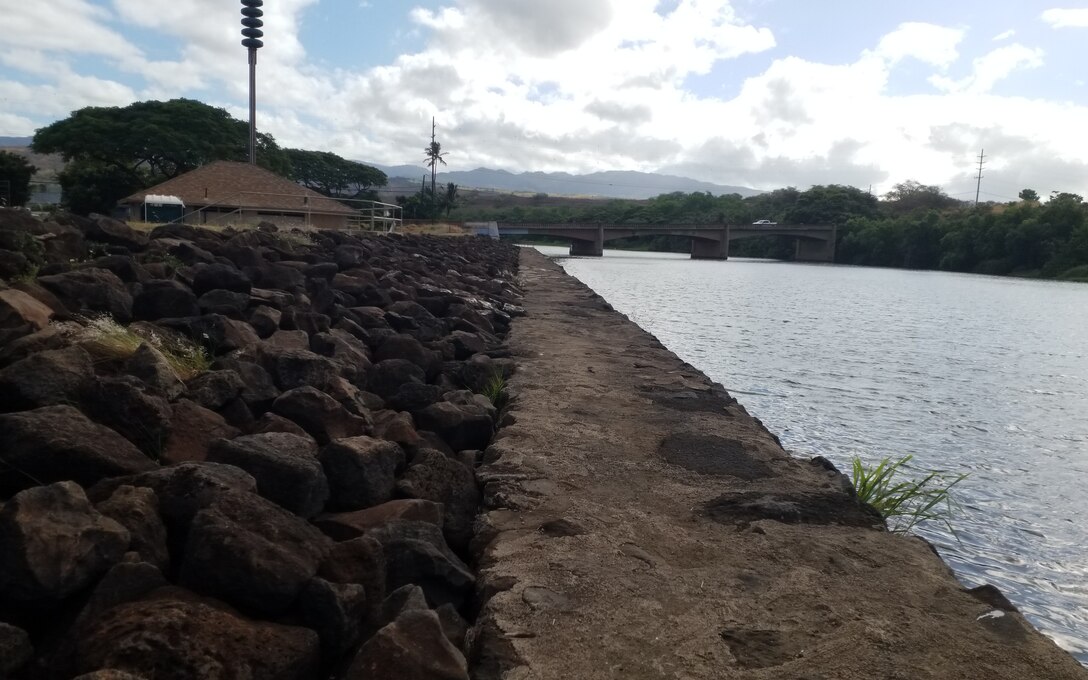 Waimea River Flood Control Project levee and concrete-rubble-masonry wall. Photo taken from right bank at Lucy Wright Park, facing upstream at Kaumuali'i Highway Bridge over Waimea River. (USACE, 2024)