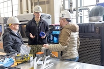 Seth Haskins, additive manufacturing manager, Shop 31, Inside Machinist, briefs Rear Adm. Peter Small Feb. 4, during a tour of Puget Sound Naval Shipyard & Intermediate Maintenance Facility facilities in Bremerton, Washington. (U.S. Navy photo by Wendy Hallmark)