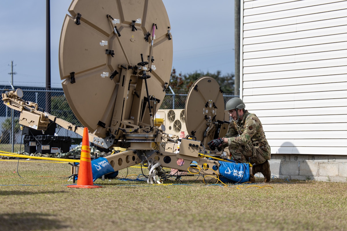 A photo of an airman working on a satellite dish