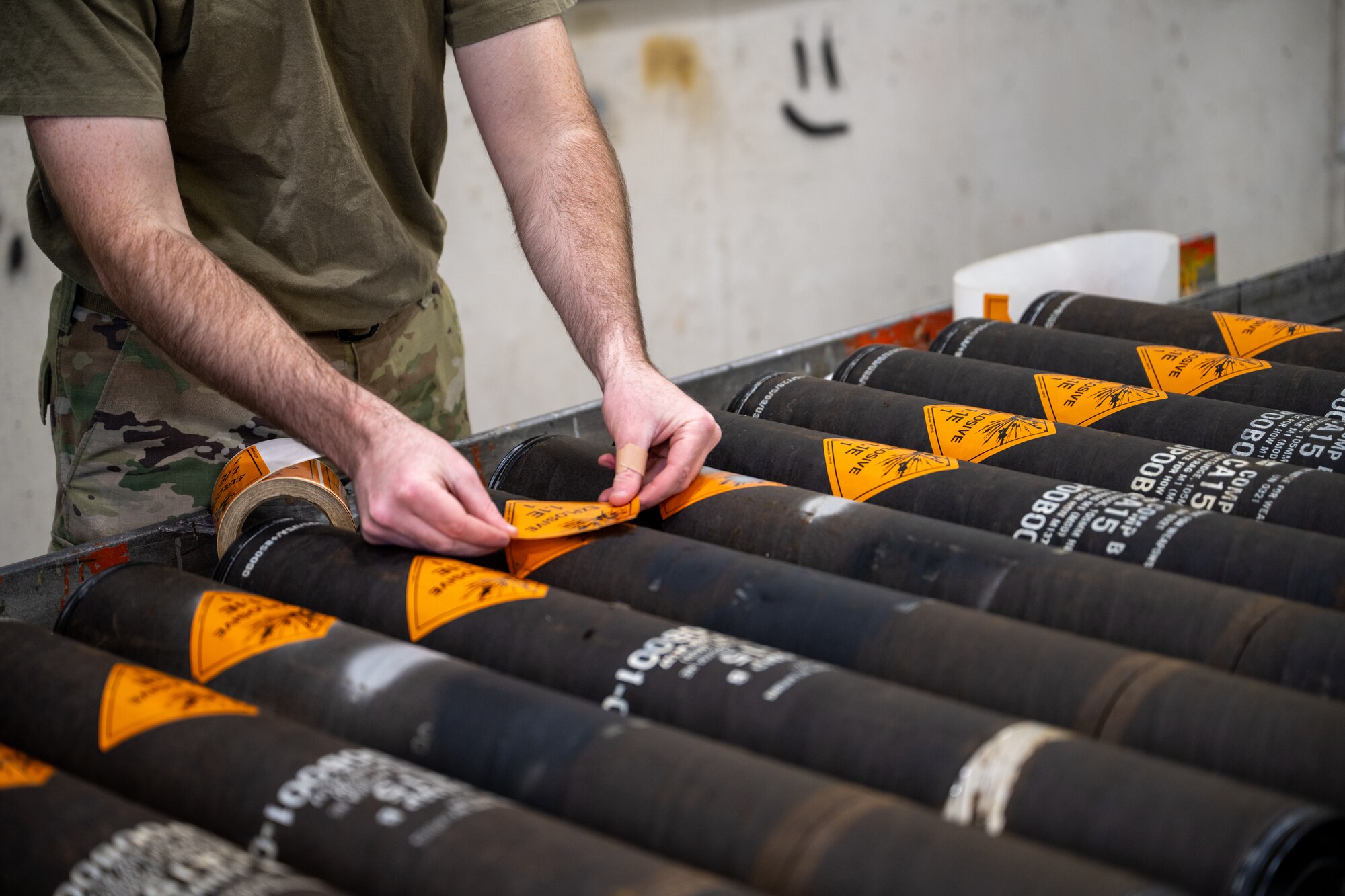 A U.S. Air Force munitions specialist assigned to the 1st Special Operations Wing applies explosive labels to artillery shells at Hurlburt Field, Florida, Jan. 15, 2025.