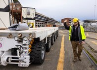 Austin Collins, rigger, Code 740, helps guide the self-propelled modular transporter near Dry Dock 5 at Puget Sound Naval Shipyard & Intermediate Maintenance Facility in Bremerton, Washington. (U.S. Navy photo by Wendy Hallmark)