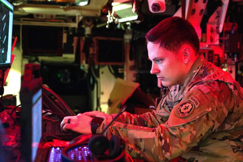 A soldier operates a laptop computer.