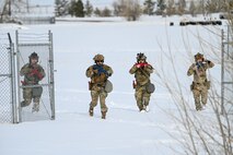 Airmen in tactical gear approach the camera.