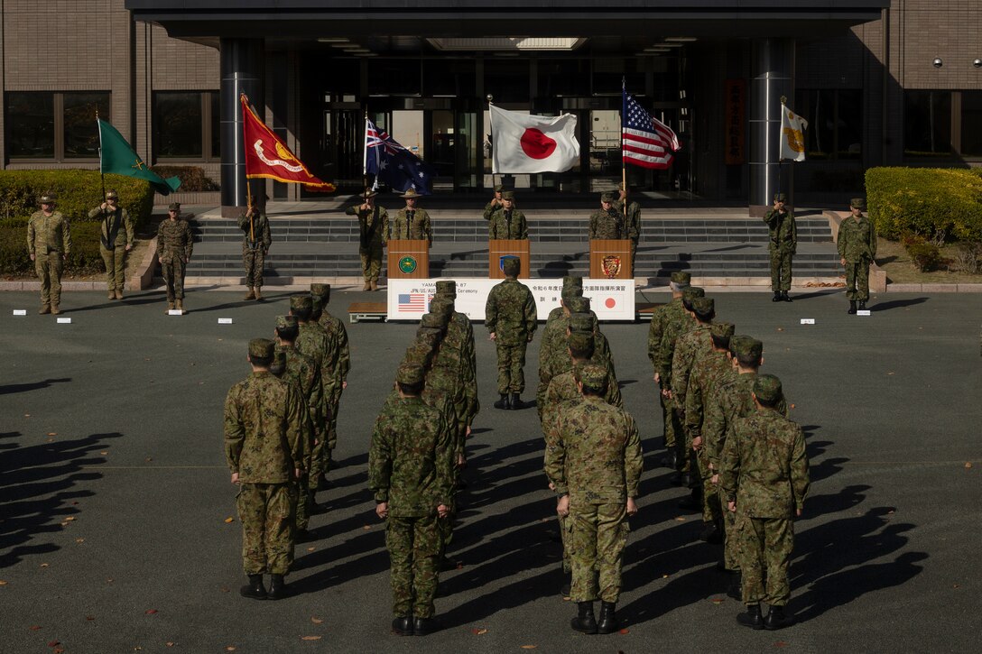 Service members of the Western Army, Japan Ground Self-Defense Force, stand at attention alongside Australian and U.S. counterparts during the closing ceremony of Exercise Yama Sakura 87 in Kumamoto, Japan Dec. 14, 2024. Yama Sakura 87 is the largest and most complex U.S. Army-Japan Ground Self-Defense Force command post exercise to date, with enhanced participation of the Australian Defense Force and U.S. Marines with III Marine Expeditionary Force. The goal of the exercise is to strengthen multi-domain and cross-domain interoperability and readiness between the U.S.-Japan alliance to ensure a free and open Indo-Pacific. (U.S. Marine Corps photo by 2nd Lt. Giovanni A. Jimenez)