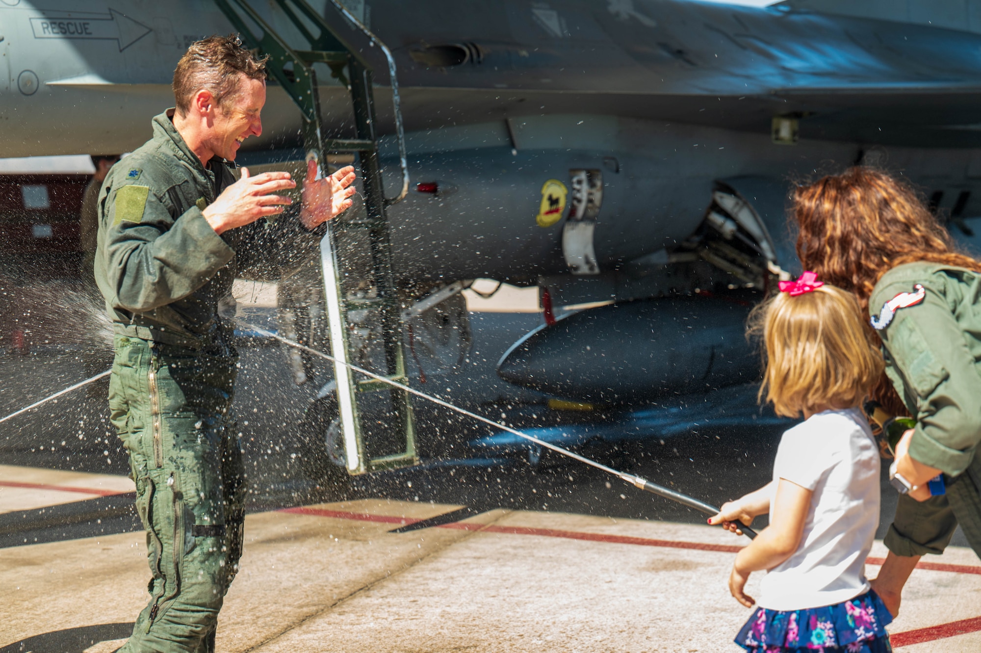 U.S. Air Force Lt. Col. Michael Ress, 309th Fighter Squadron commander, is sprayed with water by his family after completing the final F-16 Fighting Falcon flight of the 309th FS, Feb. 26, 2025, at Luke Air Force Base, Arizona.