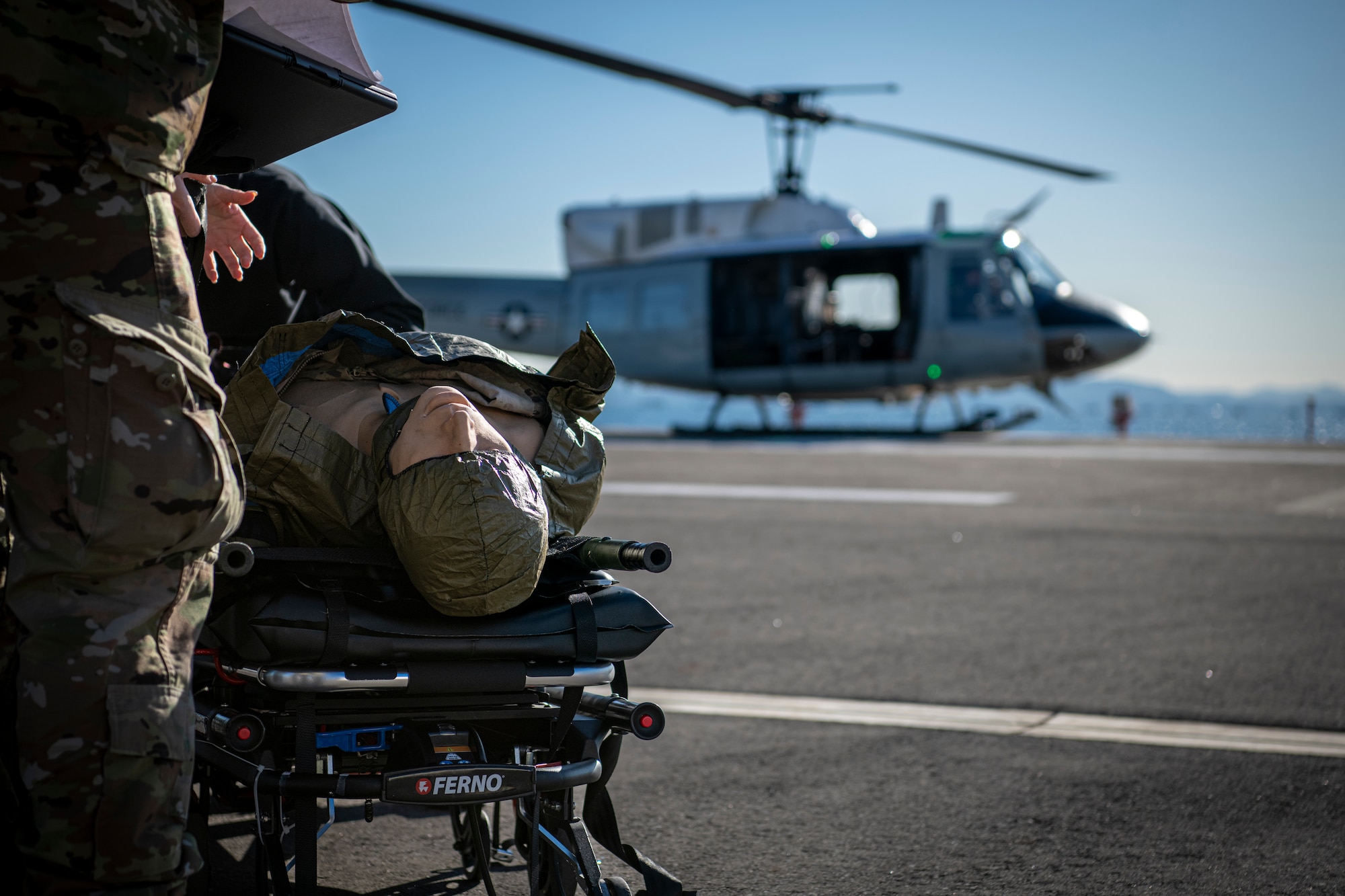 A simulated patient rests on a litter.