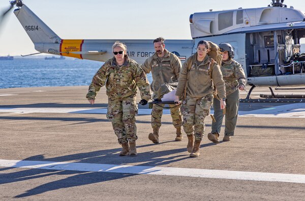 YOKOSUKA, Japan (Feb. 20, 2025) U.S. Air Force Airmen assigned to the 374th Medical Group transport a simulated patient from a UH-1N Huey assigned to the 459th Airlift Squadron from Yokota Air Base. U.S. Naval Hospital (USNH) Yokosuka and 374th Medical Group from Yokota conducted a surgical team assist and medical evacuation (MEDEVAC) operation during a joint mass casualty drill. The drill tested the efficiency of transporting a surgeon from Yokosuka to Yokota via 459th Airlift Squadron while simultaneously evacuating a Yokota-based trauma patient to a higher level of care in Yokosuka. (U.S. Navy photo by Daniel Taylor/USNMRTC Yokosuka Public Affairs)