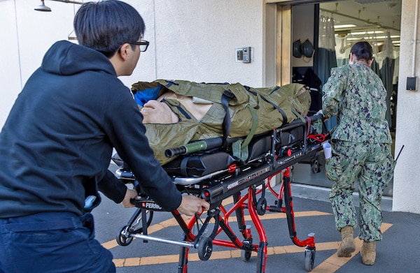 YOKOSUKA, Japan (Feb. 20, 2025) U.S. Naval Hospital (USNH) Yokosuka personnel transport a simulated patient to USNH Yokosuka during a mass casualty drill. USNH Yokosuka and 374th Medical Group from Yokota conducted a surgical team assist and medical evacuation (MEDEVAC) operation during the joint mass casualty drill. The drill tested the efficiency of transporting a surgeon from Yokosuka to Yokota via 459th Airlift Squadron while simultaneously evacuating a Yokota-based trauma patient to a higher level of care in Yokosuka. (U.S. Navy photo by Daniel Taylor/USNMRTC Yokosuka Public Affairs)
