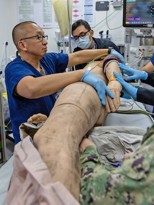 YOKOSUKA, Japan (Feb. 20, 2025) U.S. Naval Hospital (USNH) Yokosuka personnel conduct a Code Trauma Drill on a simulated patient during a mass casualty drill. USNH Yokosuka and 374th Medical Group from Yokota conducted a surgical team assist and medical evacuation (MEDEVAC) operation during the joint mass casualty drill. The drill tested the efficiency of transporting a surgeon from Yokosuka to Yokota via 459th Airlift Squadron while simultaneously evacuating a Yokota-based trauma patient to a higher level of care in Yokosuka. (U.S. Navy photo by Daniel Taylor/USNMRTC Yokosuka Public Affairs)