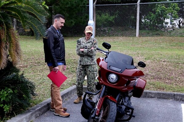 250220-N-DO281-1038 OKINAWA, Japan (Feb. 20, 2025) – Capt. Kathleen Cooperman, commanding officer, Navy Medicine Readiness and Training Command Okinawa, right, and Lt. Keegan Marcantel look over safety features of his motorcycle before a motorcycle safety ride through Okinawa, Japan, Feb. 20, 2025. (U.S. Navy photo by Mass Communication Specialist 1st Class Trey Fowler)