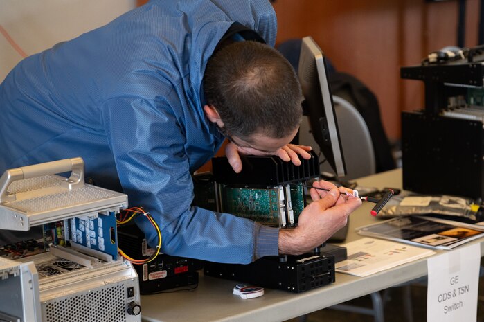A technician inserts a module into a chassis during PlugFest hosted by the Air Combat Command Federal Laboratory, Feb. 11, 2025, at Beale Air Force Base, California.