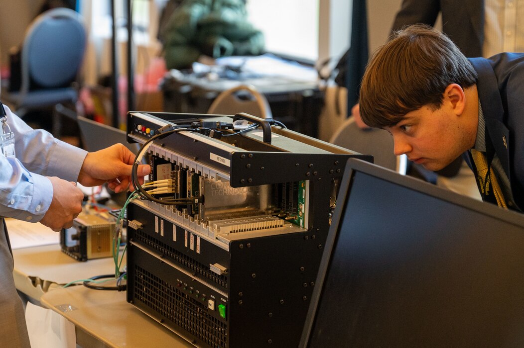 An engineer slots a module into a chassis at PlugFest on Feb. 11, 2025 at Beale Air Force Base, California.