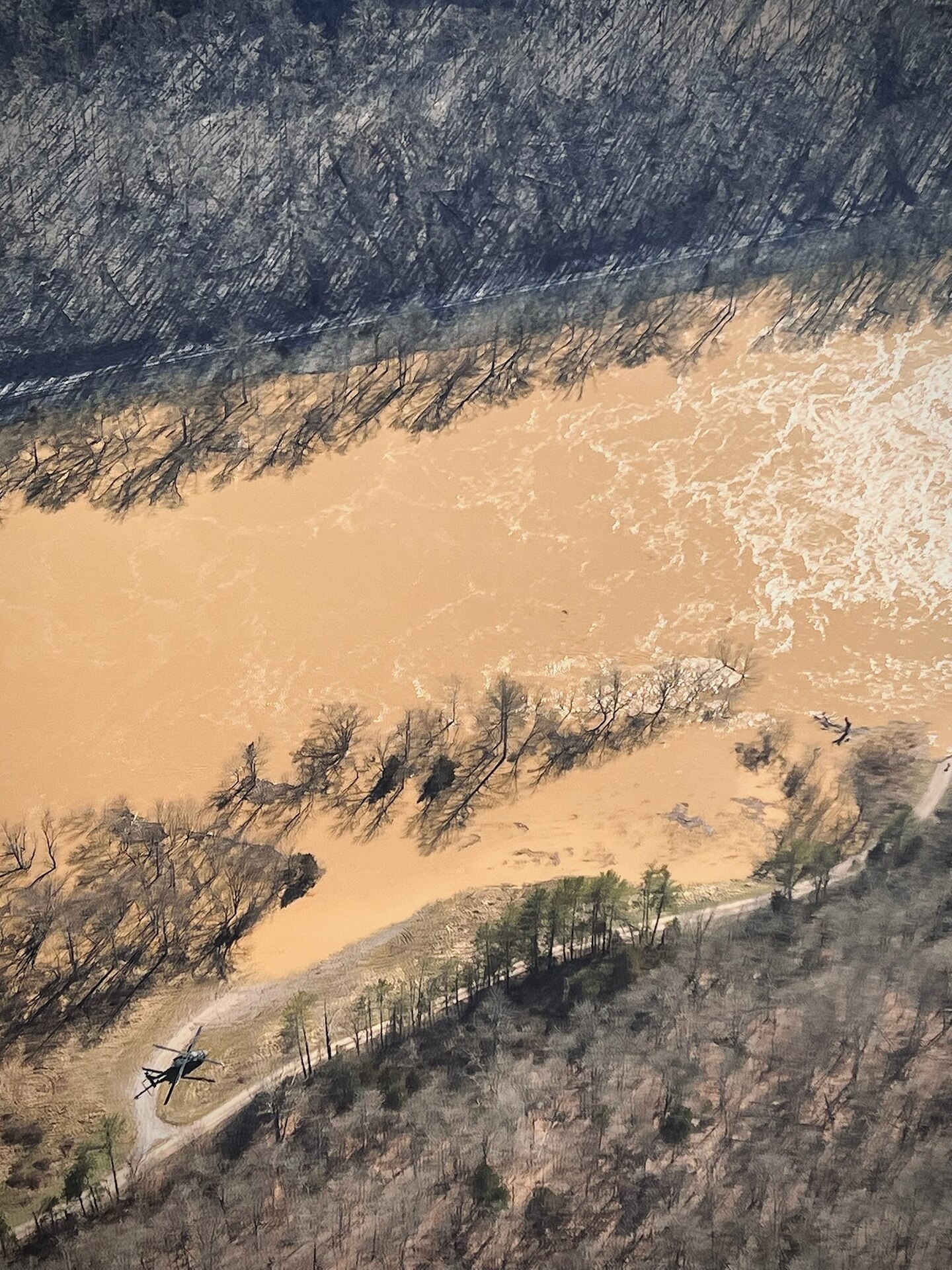 A Kentucky Army National Guard UH-60 Black Hawk lands in eastern Kentucky to check on a small boat going upstream while aiding in search efforts for stranded flood survivors on February 17, 2025.