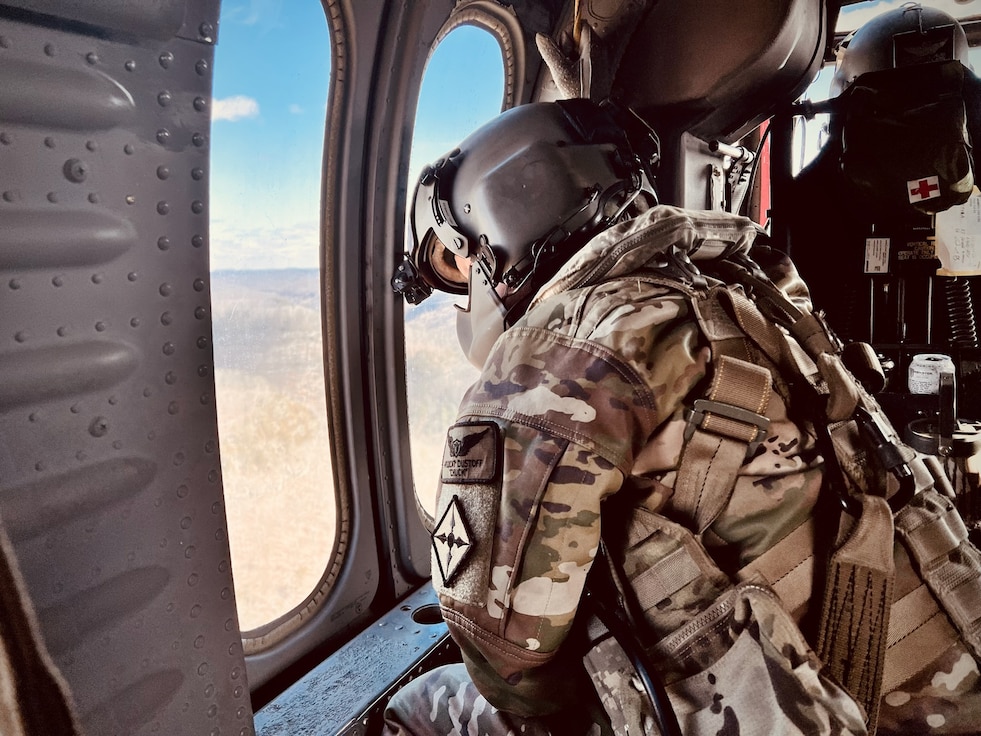 Sgt. Charles Hall, crew chief from Charlie Co 2-238th MEDEVAC, scans waterways in eastern Kentucky for stranded flood survivors on February 17, 2025.