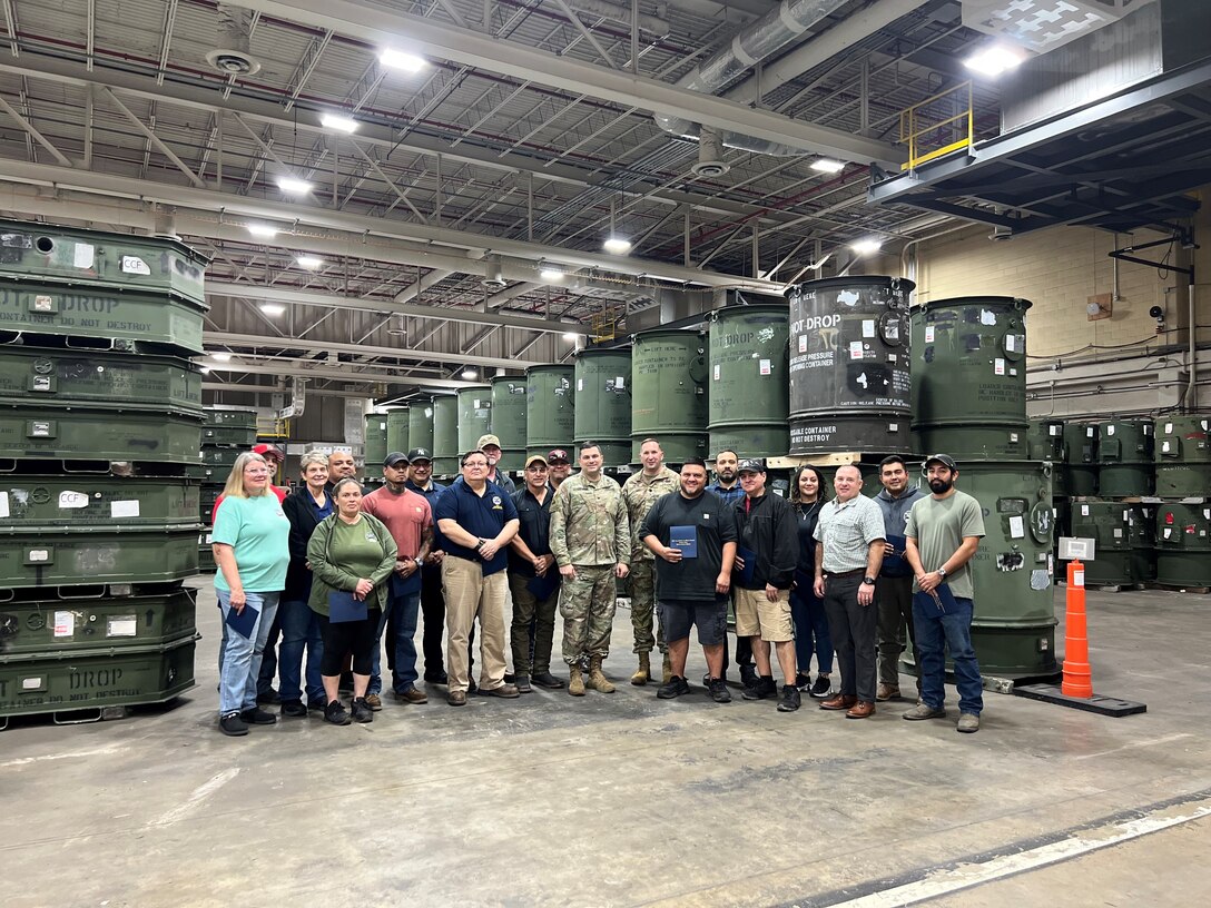 Employees receive awards in a warehouse.