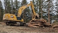 A Soldier from the 149th EVCC stacks fallen trees along the rough graded road heading toward Shepard Point.