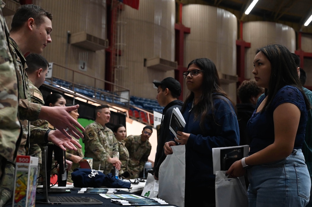 U.S. Air Force service members speak with a local high school student at the SPARK Youth Career Expo, Foster Communication Coliseum, San Angelo, Feb. 26, 2025. Airmen engaged with students through interactive displays and conversations, sharing insights into military life, educational benefits and leadership opportunities. (U.S. Air Force photo by Senior Airman Madi Collier)