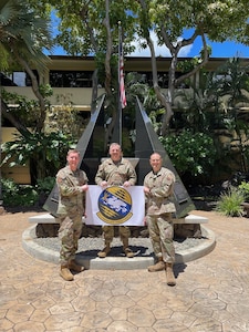 Command team stands in front of sign in Hawaii