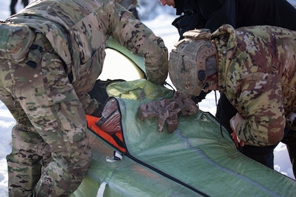Exercise Special Operations Forces Arctic Medic 2025 participants load a simulated combat casualty into a CASEVAC Ecosystem sled prototype at Yukon Training Area, Alaska, Feb. 18, 2025. SOFAM 2025 prepared its participants to conduct medical operations in extreme cold.