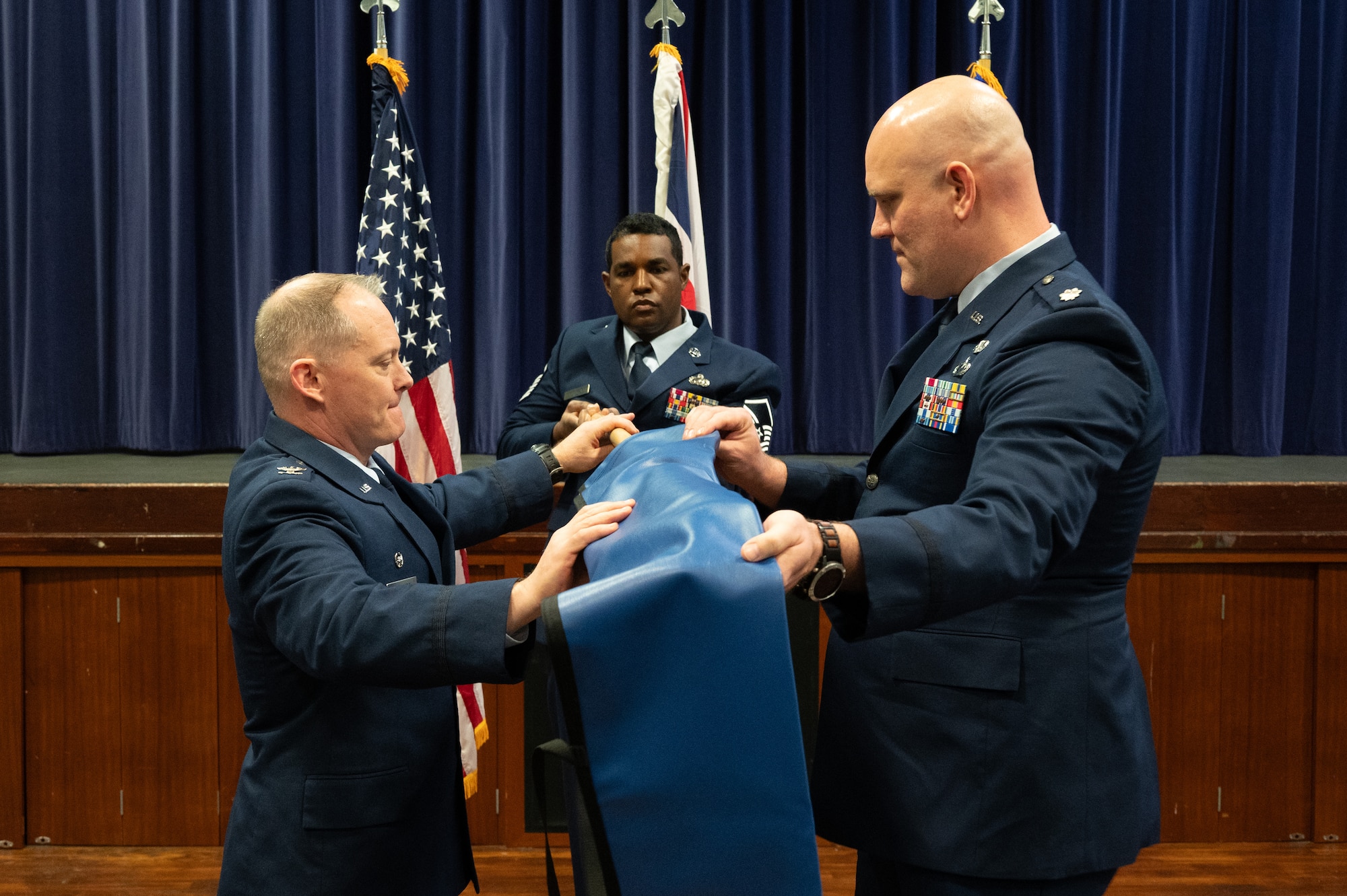 U.S. Air Force Col. D. Landon Phillips, 501st Combat Support Wing commander, left, and Lt. Col. Brian Erickson, 501st Combat Support Wing Comptroller Squadron commander, right, unveil the squadron flag during the 501st CSW Comptroller Squadron stand-up ceremony