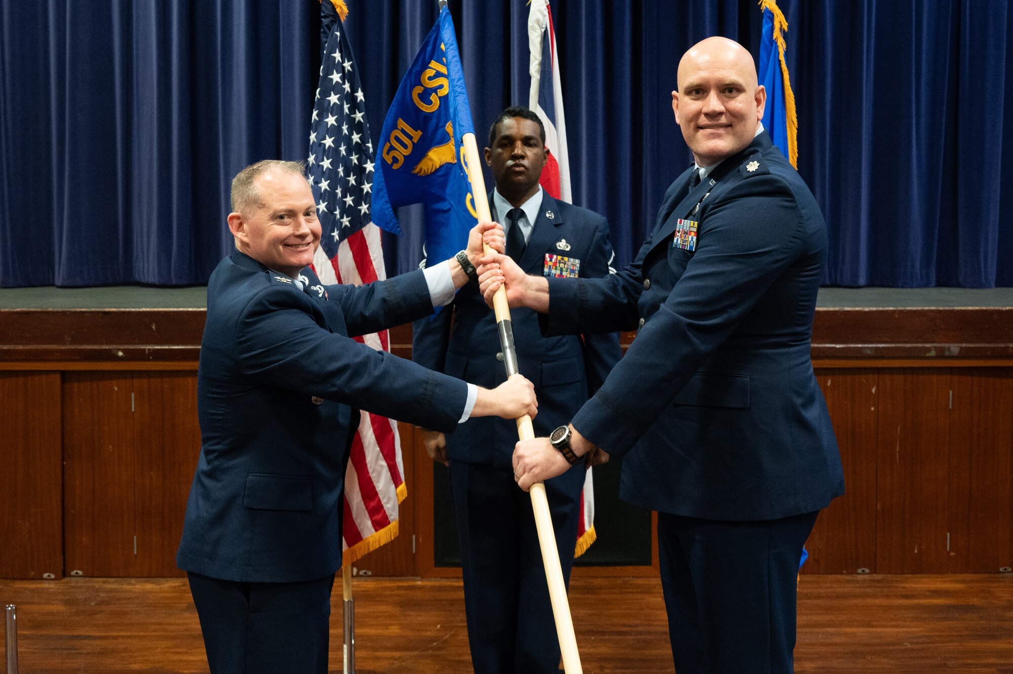 U.S. Air Force Lt. Col. Brian Erickson, 501st Combat Support Wing Comptroller Squadron commander, right, accepts command from Col. D. Landon Phillips, 501st Combat Support Wing commander, left, during the 501st CSW Comptroller Squadron stand-up ceremony