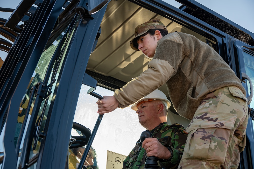 U.S. Air Force Capt. Adriana Amador provides translation support for a Portuguese Air Force member while he operates a vehicle during an ADR exercise. From Feb.1-8, 2025, at Morón Air Base, Spain, U.S., Spanish, and Portuguese military forces conducted an Airfield Damage Repair exercise. Scholars from the Language Enabled Airman Program played a key role by providing real-time translation and cultural expertise, ensuring communication between the multinational team. Their contributions enhanced interoperability, improved safety, and strengthened partnerships throughout the exercise. (U.S. Air Force photo by Cristina Oliveira)